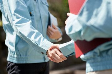 作業服姿のスタッフ同士の握手